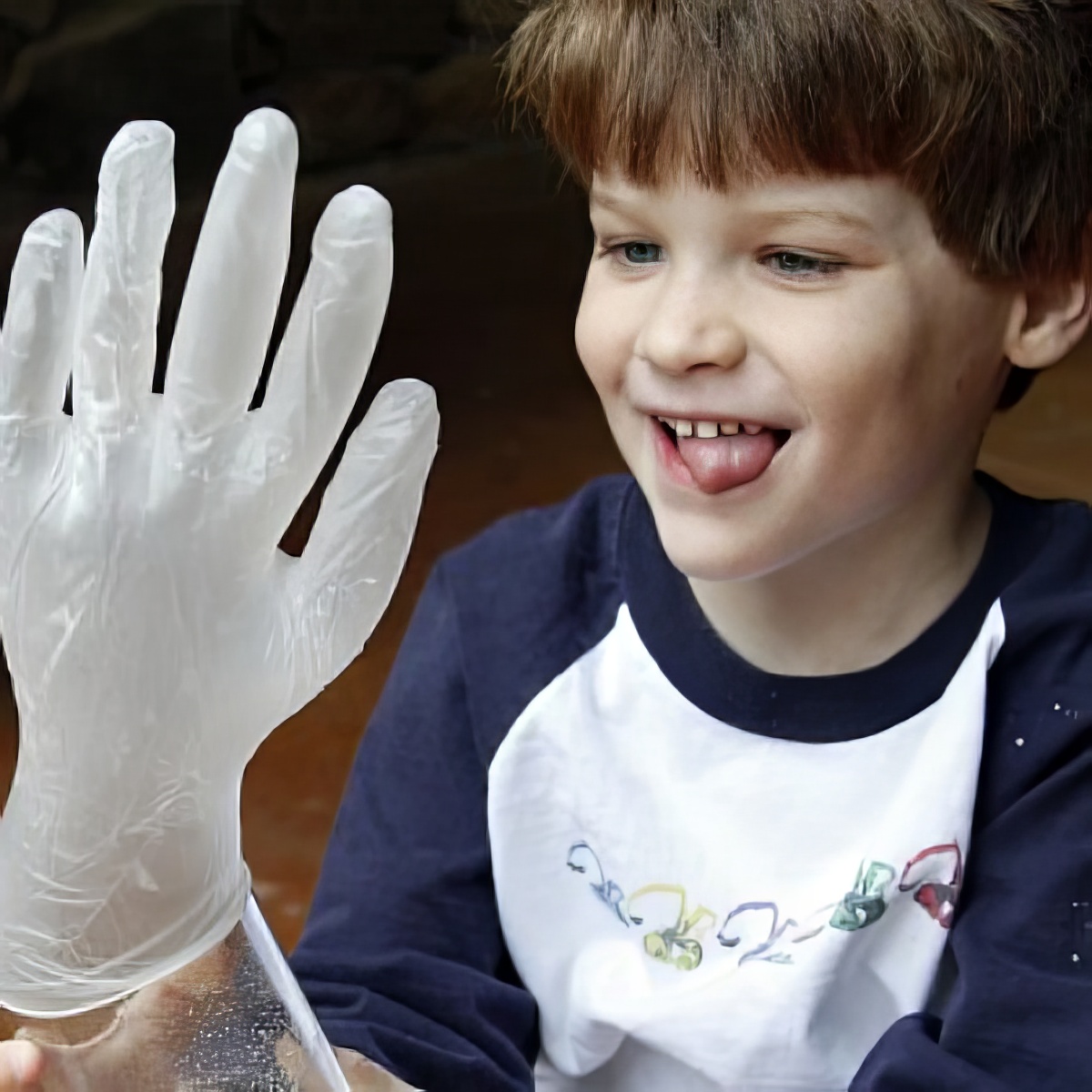 Chemical Reaction for kids, boy with tongue out holding a glove