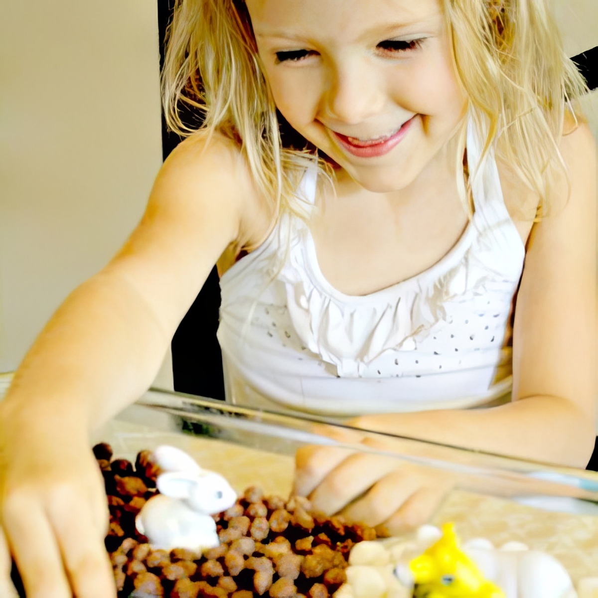little girl playing with an edible zoo sensory bin as sensory bins for preschoolers
