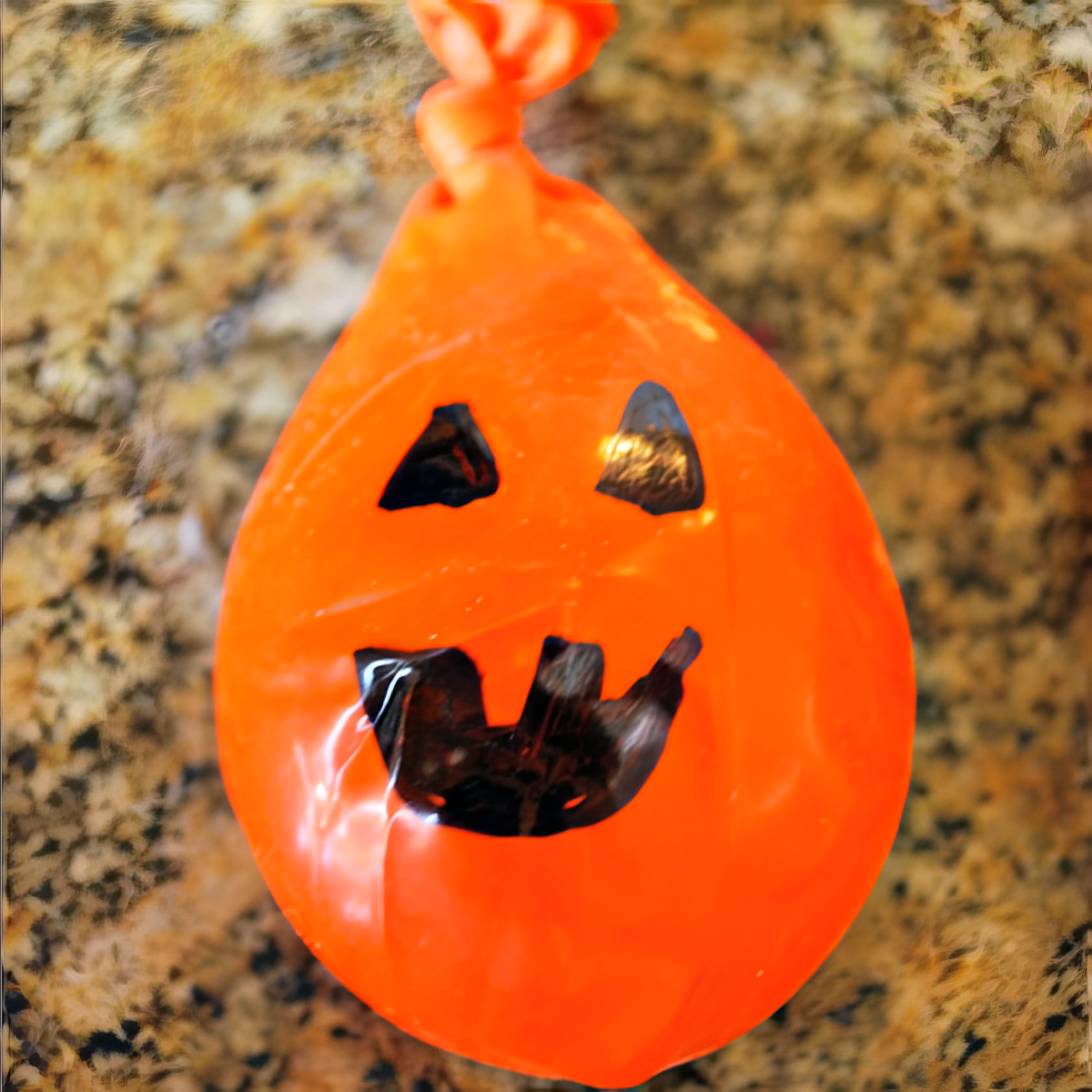 orange inflated balloon with a ghost face used for a toss game as halloween activities for 4 year olds