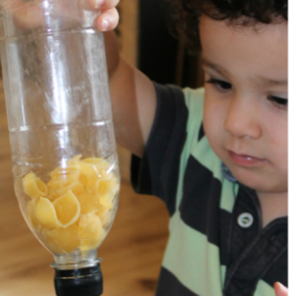 pasta musical shaker - toddler shaking plastic bottle with pasta shells inside