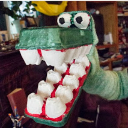 Green dragon puppet made of egg cartons with several big teeth