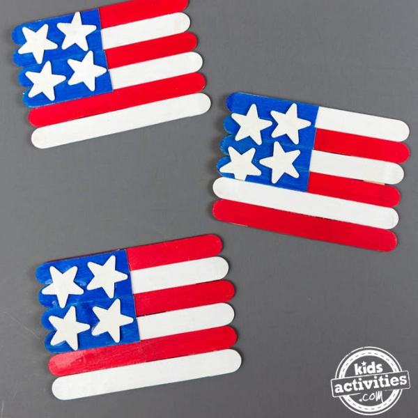 3 American flags made out of popsicle sticks with wooden stars in red white and blue from Kids Activities Blog